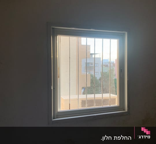 חלון זכוכית במסגרת אלומיניום לבנה מותקן בקיר החדר